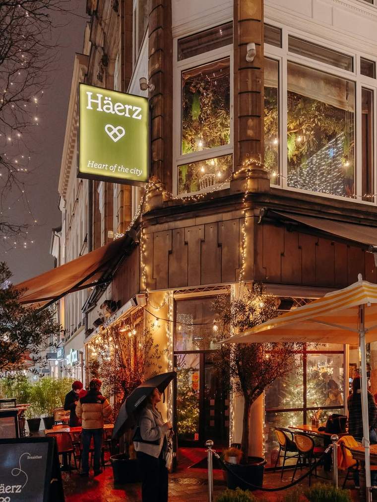 Häerz at night: the lit corner facade on Grand-Rue, under its awnings and fairy lights.