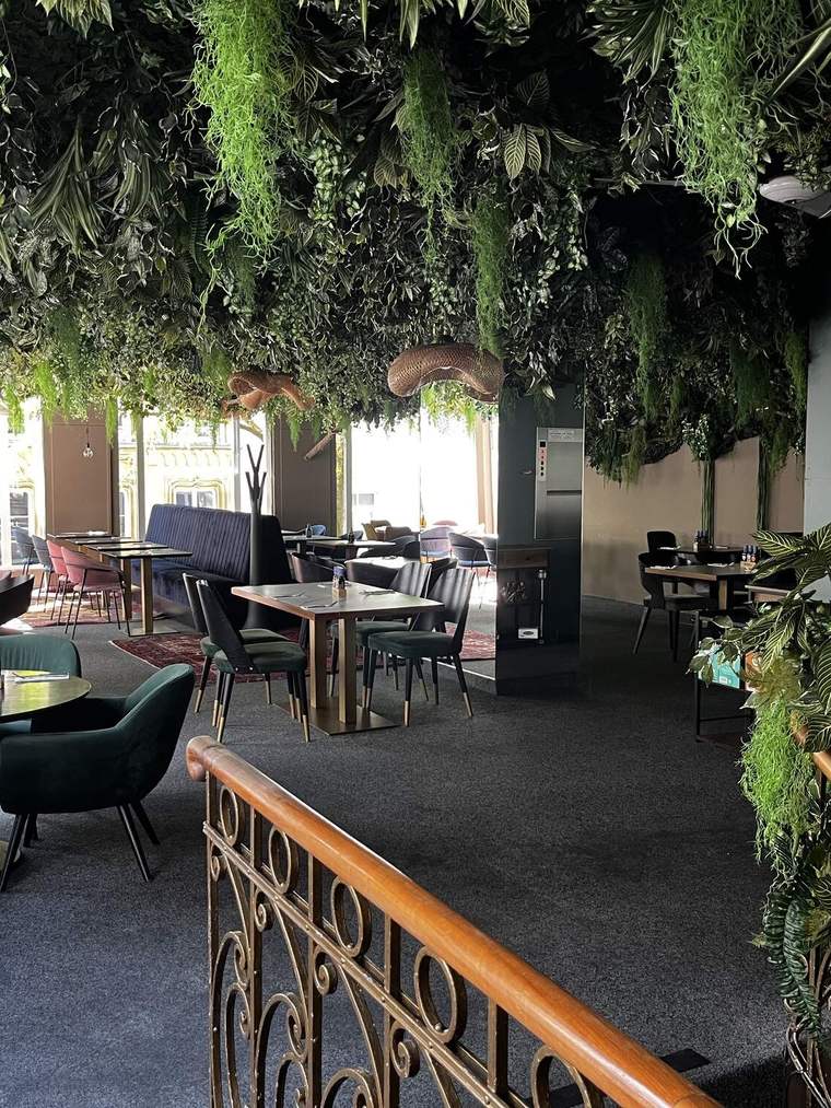 The upper floor at Häerz, hung with greenery above the tables — where the party will be.
